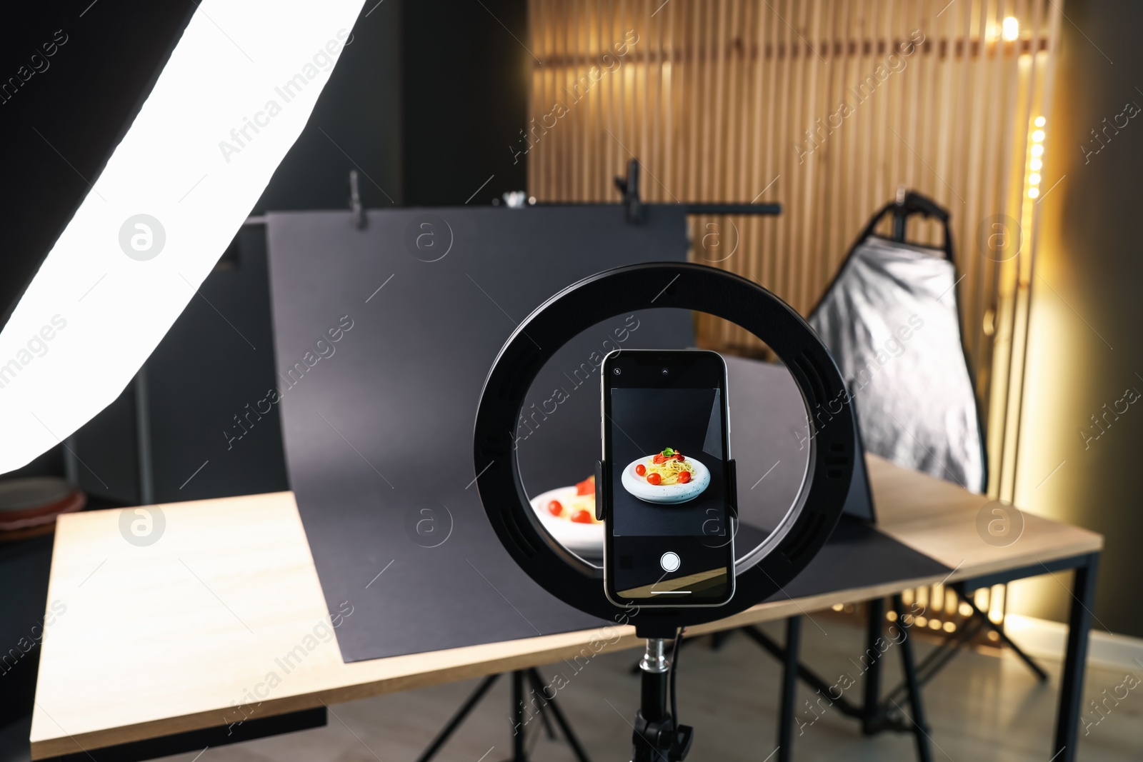 Photo of Shooting tasty pasta with smartphone in studio, focus on screen. Professional food photography