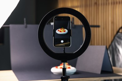 Photo of Shooting tasty pasta with smartphone in studio, focus on screen. Professional food photography