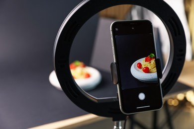 Photo of Shooting tasty pasta with smartphone in studio, focus on screen. Professional food photography