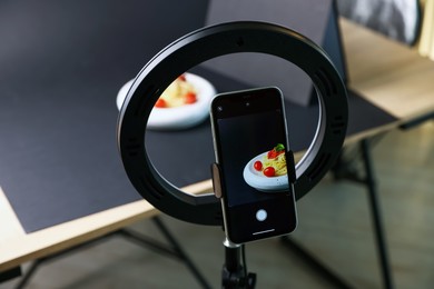 Photo of Shooting tasty pasta with smartphone in studio, focus on screen. Professional food photography