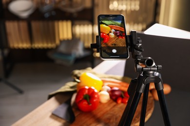 Photo of Shooting vegetables with smartphone in studio, focus on screen. Professional food photography