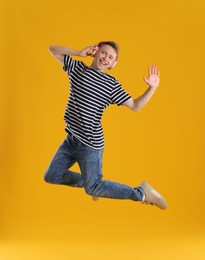 Photo of Happy young man with headphones jumping on orange background