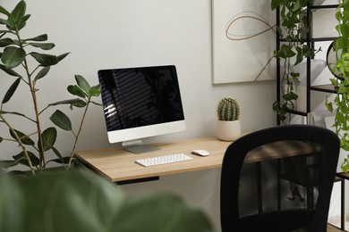 Photo of Biophilic interior design. Stylish workplace with computer and houseplants in office