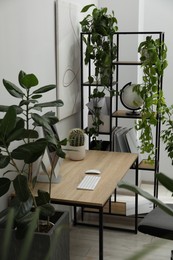 Photo of Biophilic interior design. Stylish workplace with computer and houseplants in office