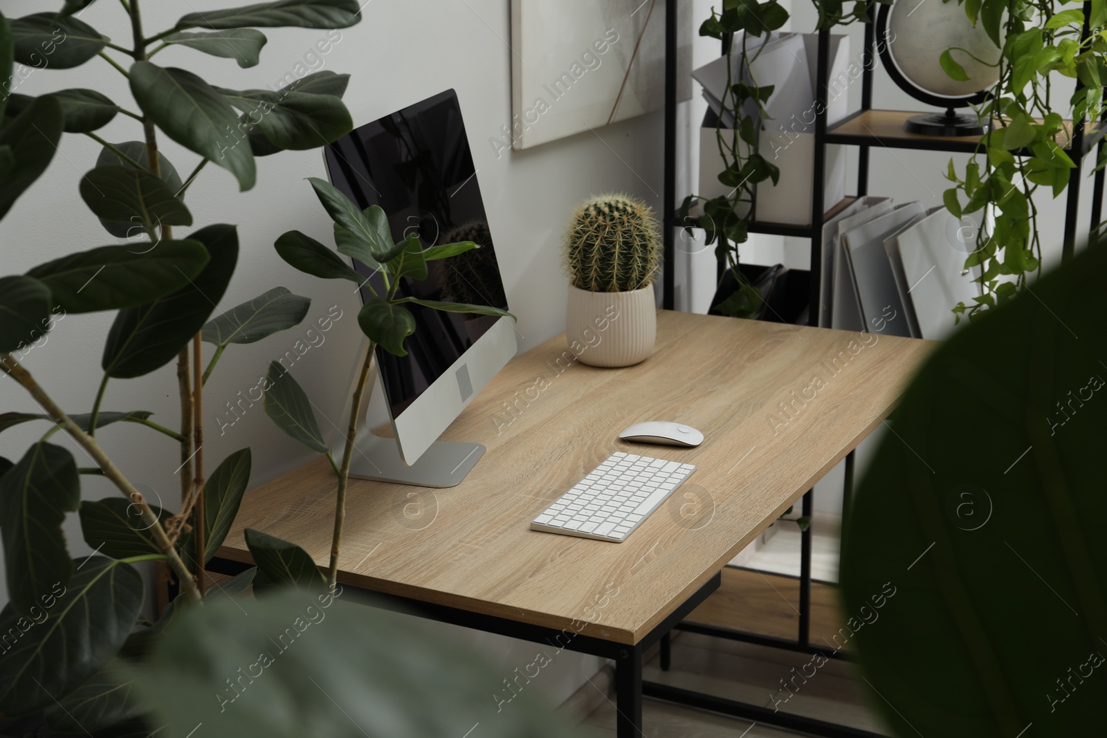 Photo of Biophilic interior design. Stylish workplace with computer and houseplants in office