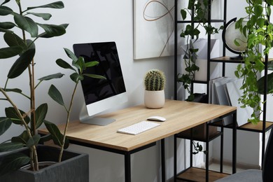 Photo of Biophilic interior design. Stylish workplace with computer and houseplants in office