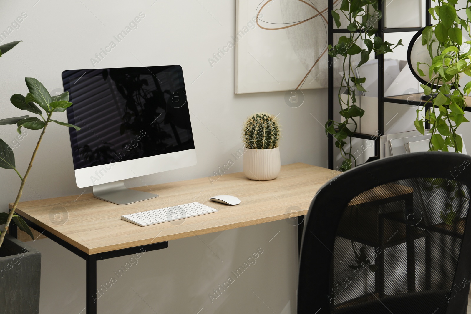 Photo of Biophilic interior design. Stylish workplace with computer and houseplants in office