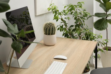Photo of Biophilic interior design. Stylish workplace with computer and houseplants in office