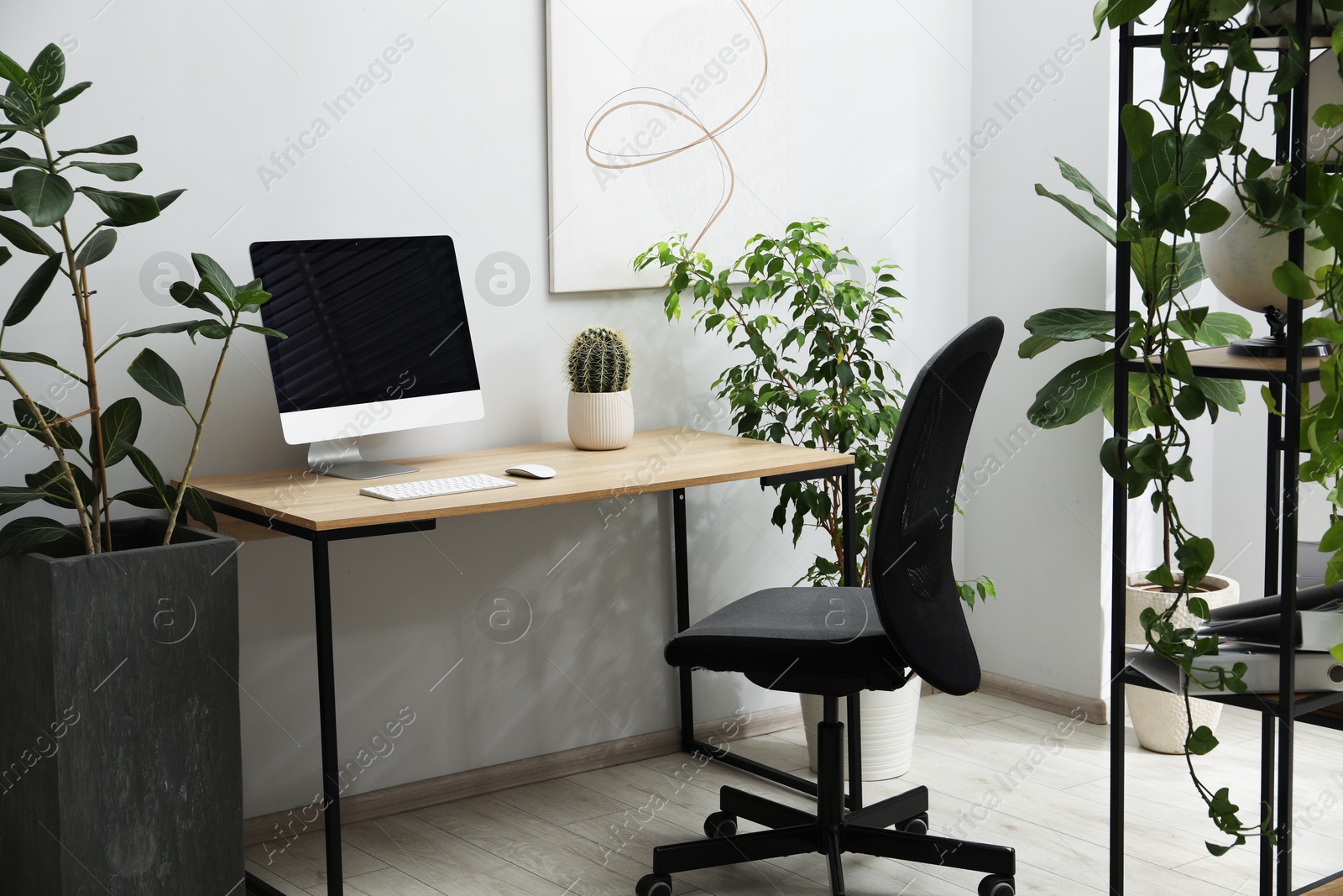 Biophilic interior design. Stylish workplace with computer and houseplants in office Photo of Biophilic interior design. Stylish workplace with computer and houseplants in office