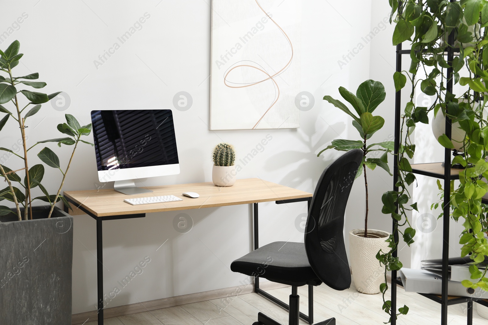 Photo of Biophilic interior design. Stylish workplace with computer and houseplants in office