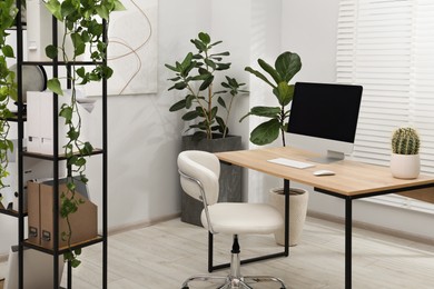 Photo of Biophilic interior design. Stylish workplace with computer and houseplants in office