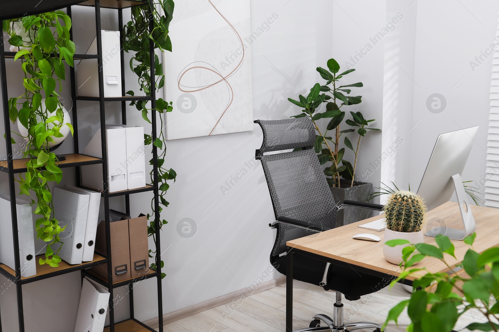 Photo of Biophilic interior design. Stylish workplace with computer and houseplants in office