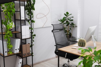Photo of Biophilic interior design. Stylish workplace with computer and houseplants in office