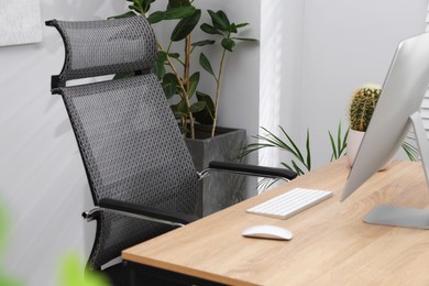 Photo of Biophilic interior design. Stylish workplace with computer and houseplants in office