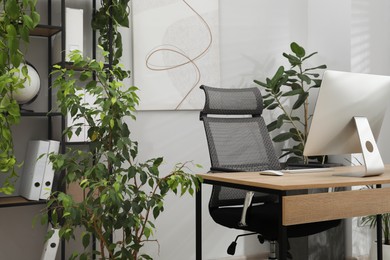 Photo of Biophilic interior design. Stylish workplace with computer and houseplants in office