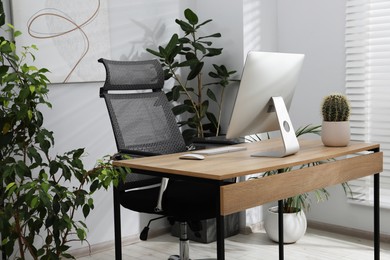 Photo of Biophilic interior design. Stylish workplace with computer and houseplants in office