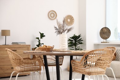 Photo of Stylish table with chairs and decor in dining room. Interior design