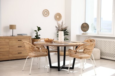 Photo of Stylish table with chairs and decor in dining room. Interior design