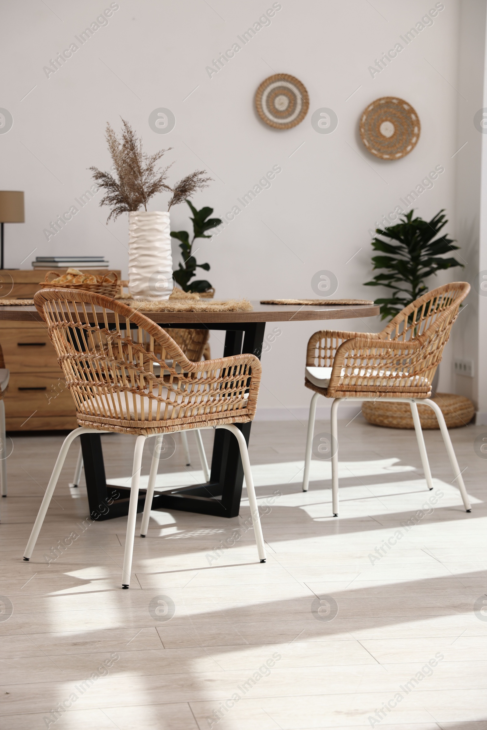 Photo of Stylish table with chairs and decor in dining room. Interior design