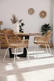 Photo of Stylish table with chairs and decor in dining room. Interior design