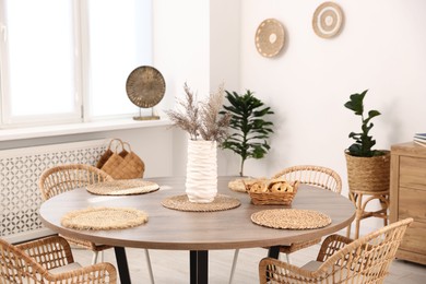 Photo of Stylish table with chairs and decor in dining room. Interior design