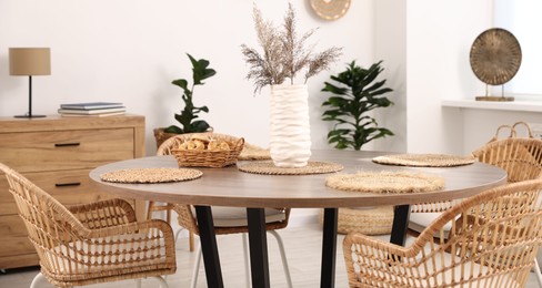 Photo of Stylish table with chairs and decor in dining room. Interior design