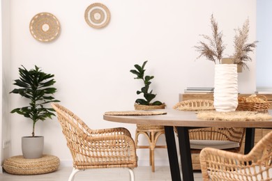 Photo of Stylish table with chairs and decor in dining room. Interior design