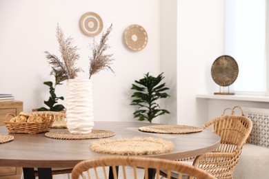 Photo of Stylish table with chairs and decor in dining room. Interior design