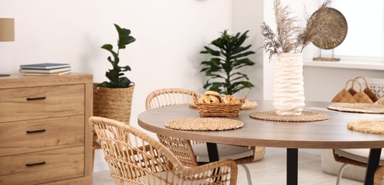 Photo of Stylish table with chairs and decor in dining room. Interior design