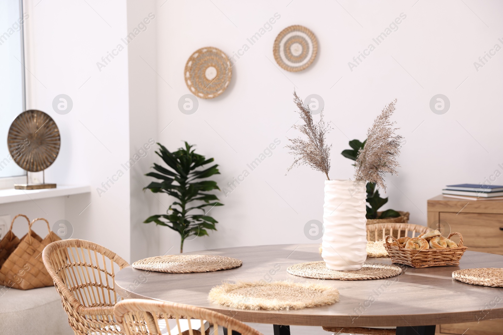 Photo of Stylish table with chairs and decor in dining room. Interior design