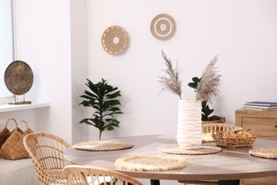Photo of Stylish table with chairs and decor in dining room. Interior design