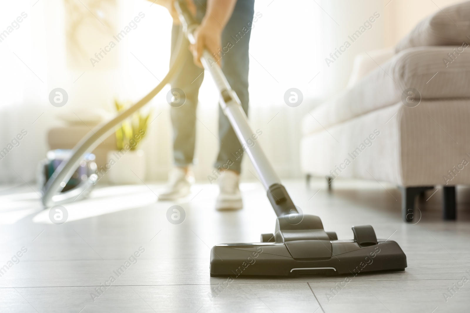 Photo of Man cleaning floor with vacuum cleaner at home, closeup
