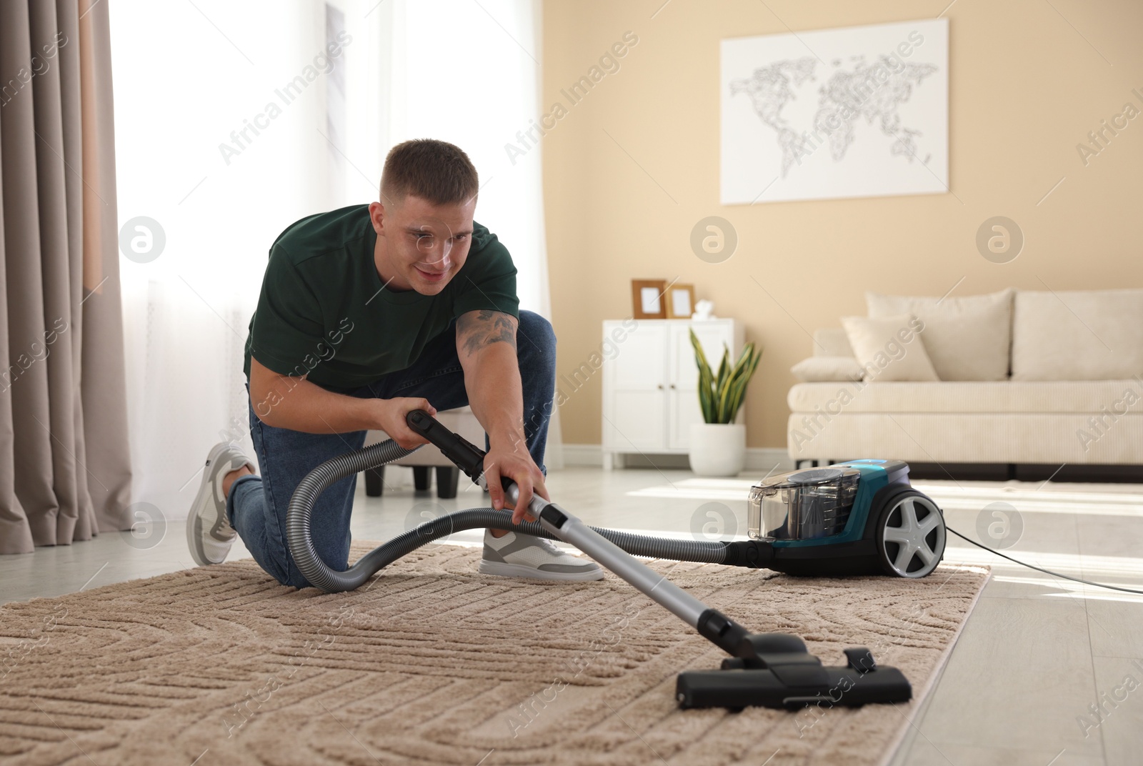 Man cleaning carpet with vacuum cleaner at home Photo of Man cleaning carpet with vacuum cleaner at home