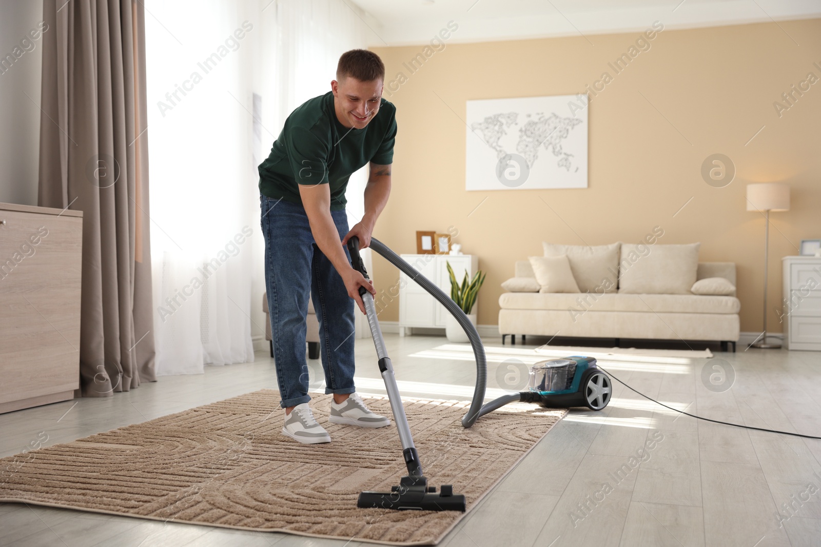 Man cleaning carpet with vacuum cleaner at home Photo of Man cleaning carpet with vacuum cleaner at home