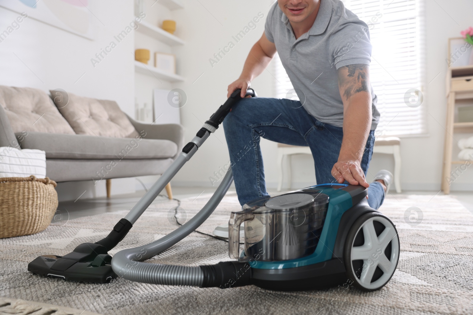 Man turning on vacuum cleaner at home, closeup Photo of Man turning on vacuum cleaner at home, closeup
