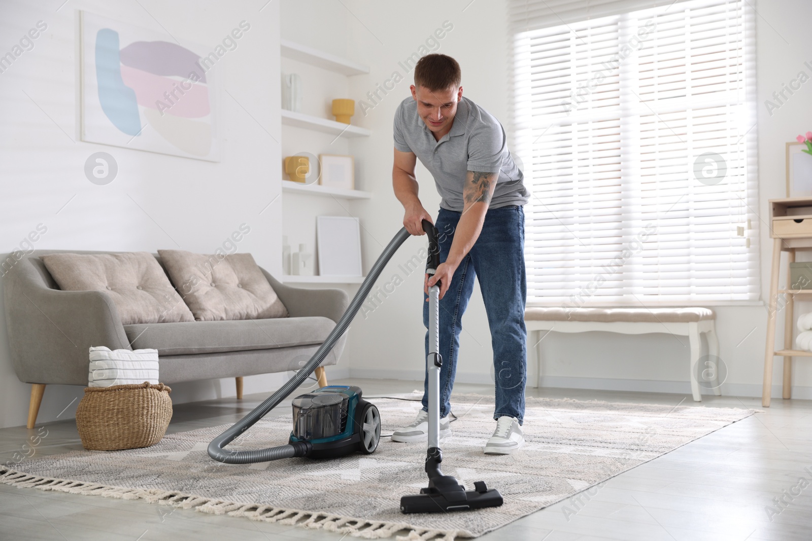 Man cleaning carpet with vacuum cleaner at home Photo of Man cleaning carpet with vacuum cleaner at home