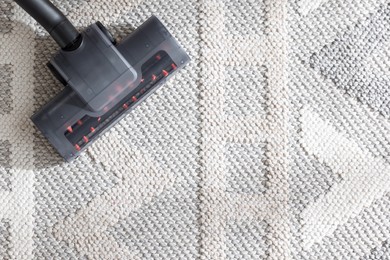 Photo of One vacuum cleaner nozzle on carpet, top view. Space for text
