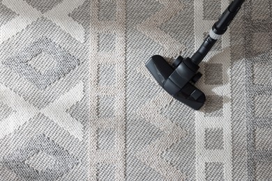 Photo of One vacuum cleaner nozzle on carpet, top view. Space for text