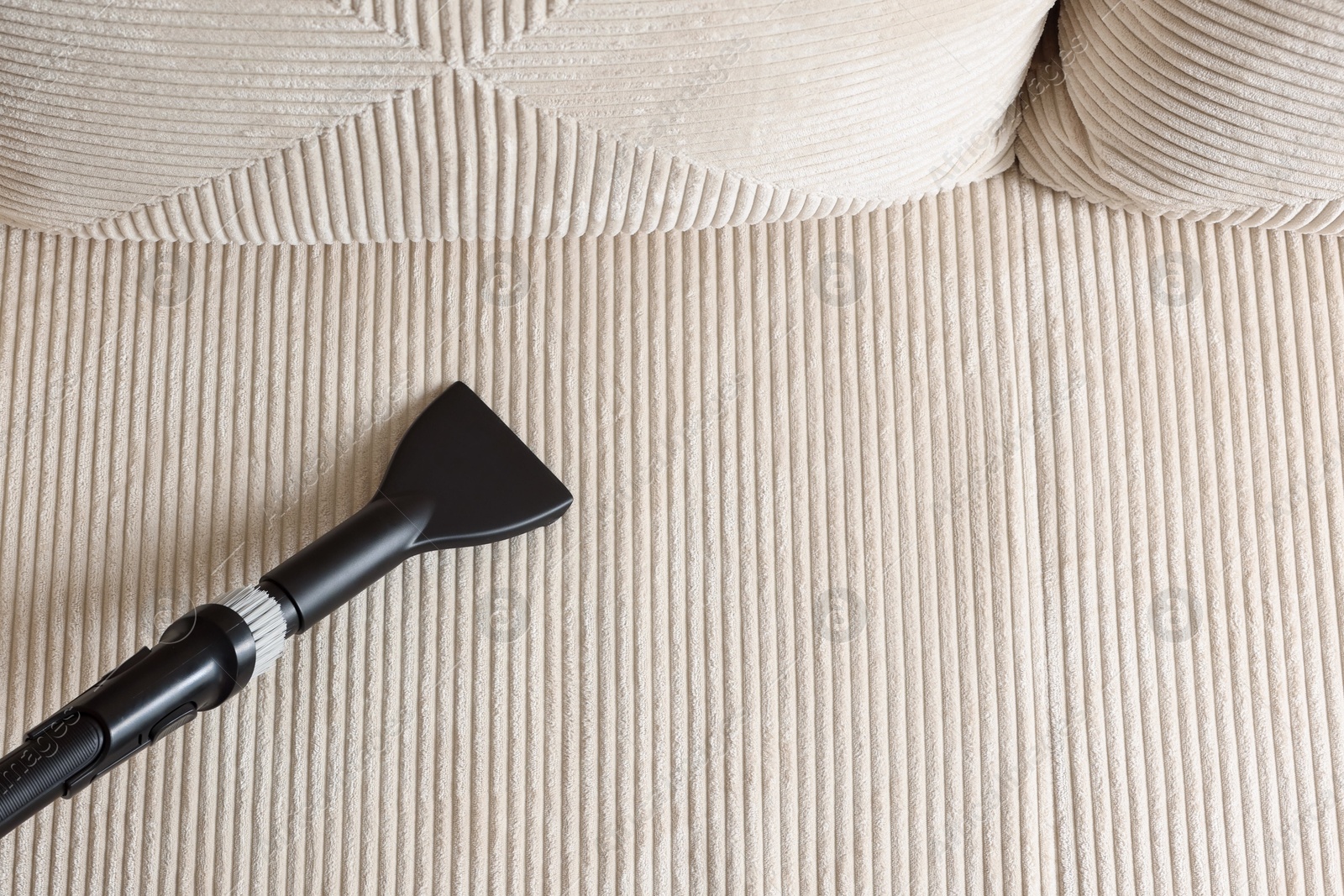 One vacuum cleaner nozzle on sofa, top view. Space for text Photo of One vacuum cleaner nozzle on sofa, top view. Space for text
