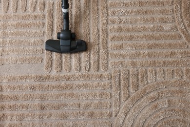 Photo of One vacuum cleaner nozzle on carpet, top view. Space for text