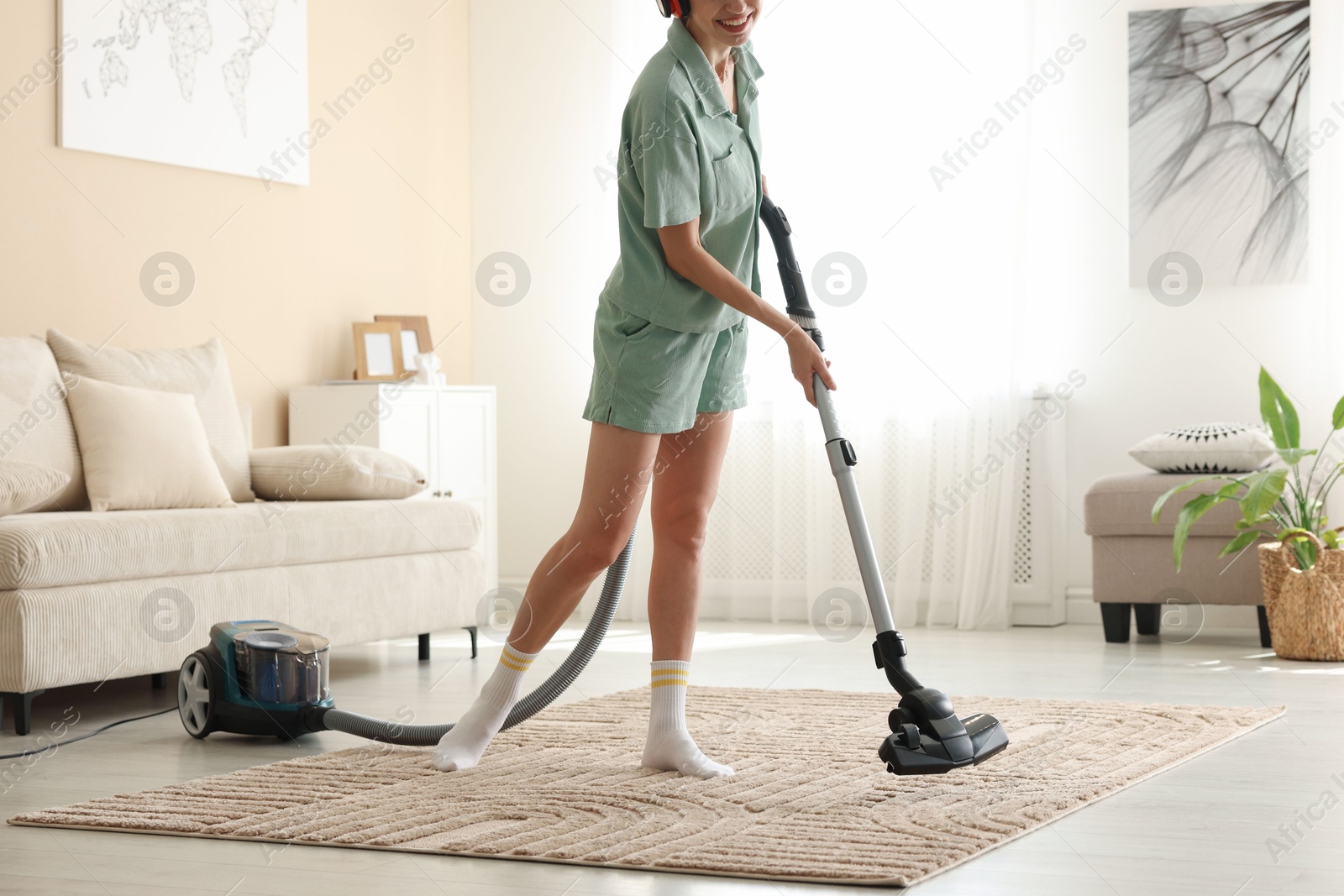 Woman cleaning carpet with vacuum cleaner at home, closeup Photo of Woman cleaning carpet with vacuum cleaner at home, closeup