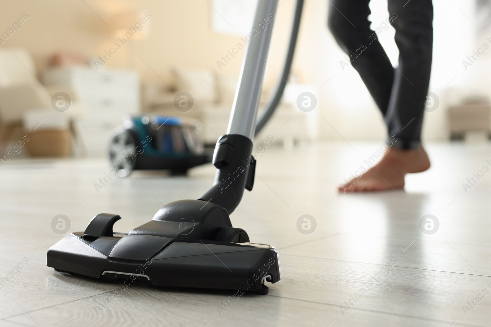 Woman cleaning floor with vacuum cleaner at home, closeup Photo of Woman cleaning floor with vacuum cleaner at home, closeup