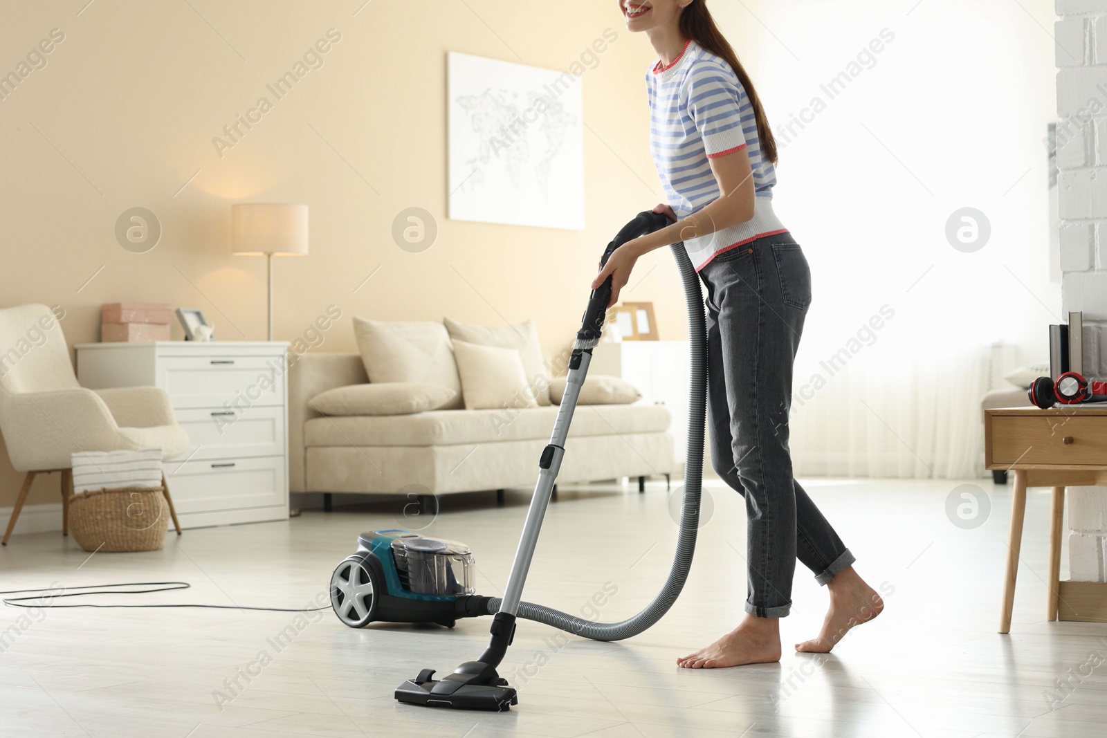 Woman cleaning floor with vacuum cleaner at home, closeup Photo of Woman cleaning floor with vacuum cleaner at home, closeup