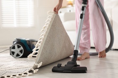 Photo of Woman cleaning floor with vacuum cleaner at home, closeup