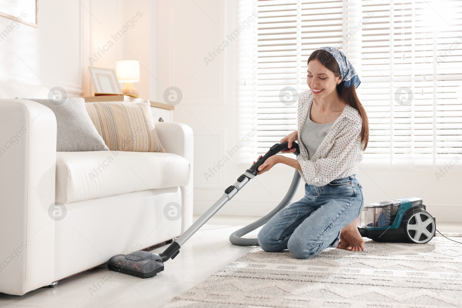 Woman cleaning floor with vacuum cleaner at home Photo of Woman cleaning floor with vacuum cleaner at home