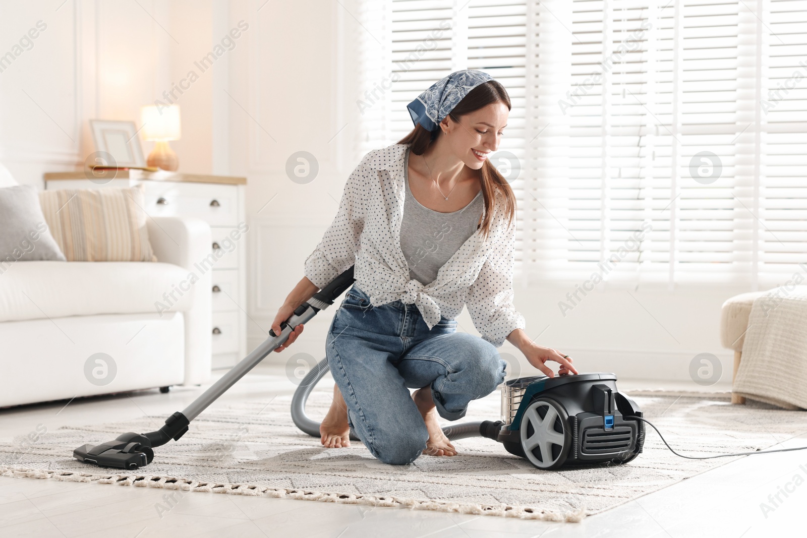 Woman cleaning carpet with vacuum cleaner at home Photo of Woman cleaning carpet with vacuum cleaner at home