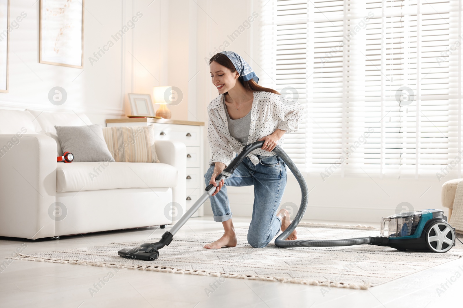 Woman cleaning carpet with vacuum cleaner at home Photo of Woman cleaning carpet with vacuum cleaner at home