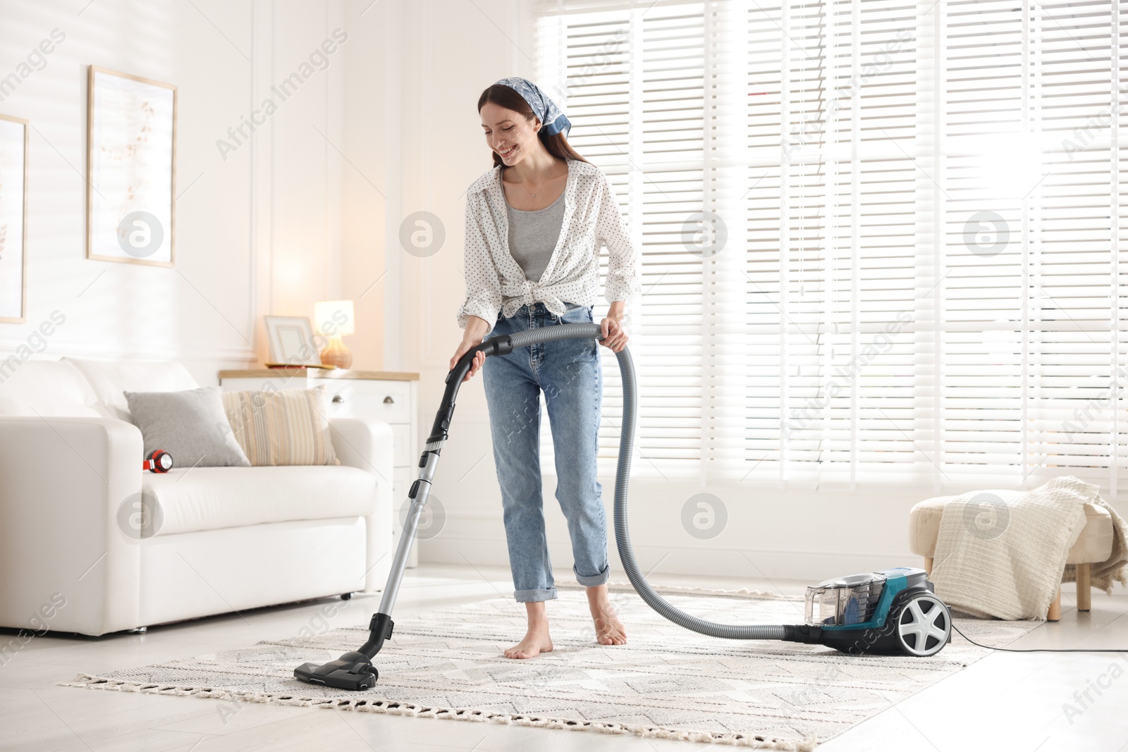 Woman cleaning carpet with vacuum cleaner at home Photo of Woman cleaning carpet with vacuum cleaner at home