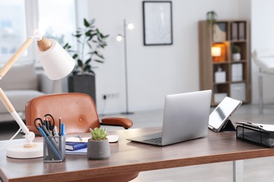Photo of Doctor's workplace with modern laptop on desk in office