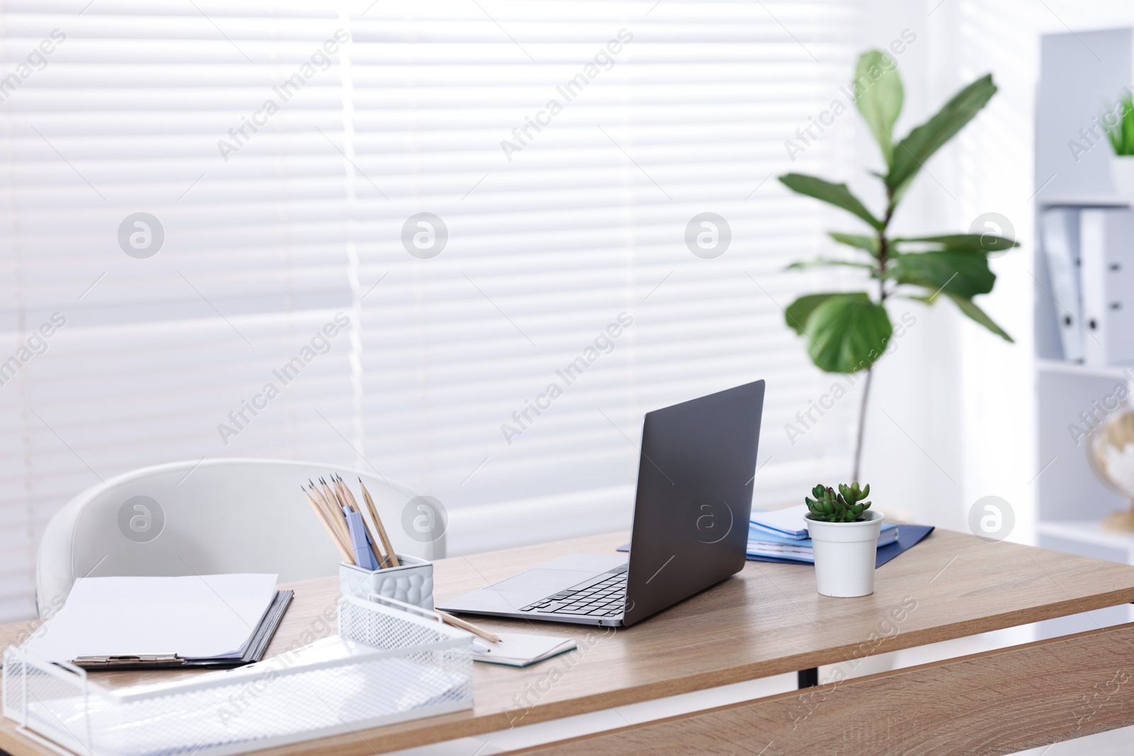 Photo of Doctor's workplace with modern laptop on desk in office